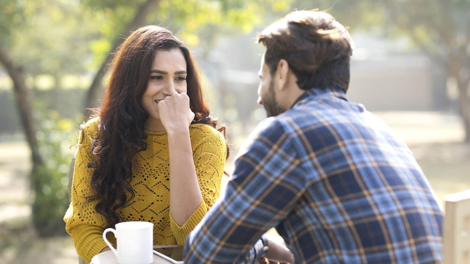 couple with digital tablet and coffee cup at park