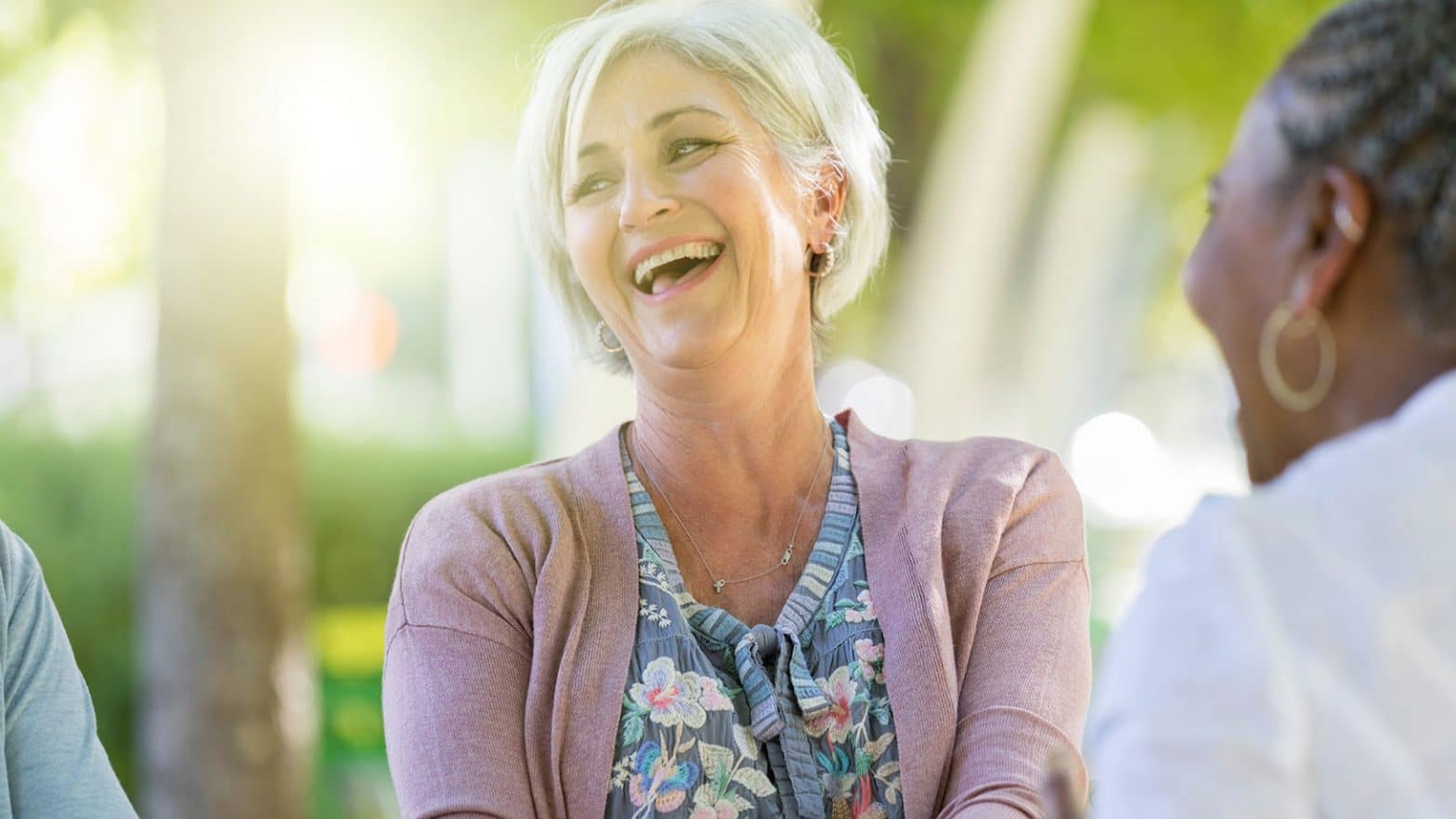 Laughing senior woman enjoys time with friends