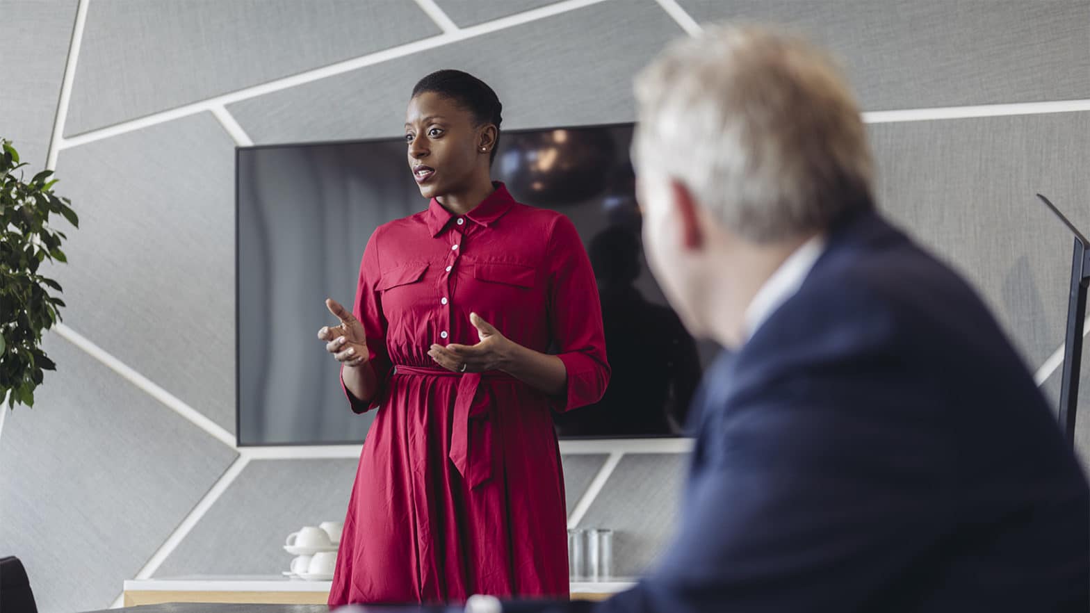 Professional woman in red dress giving a presentation